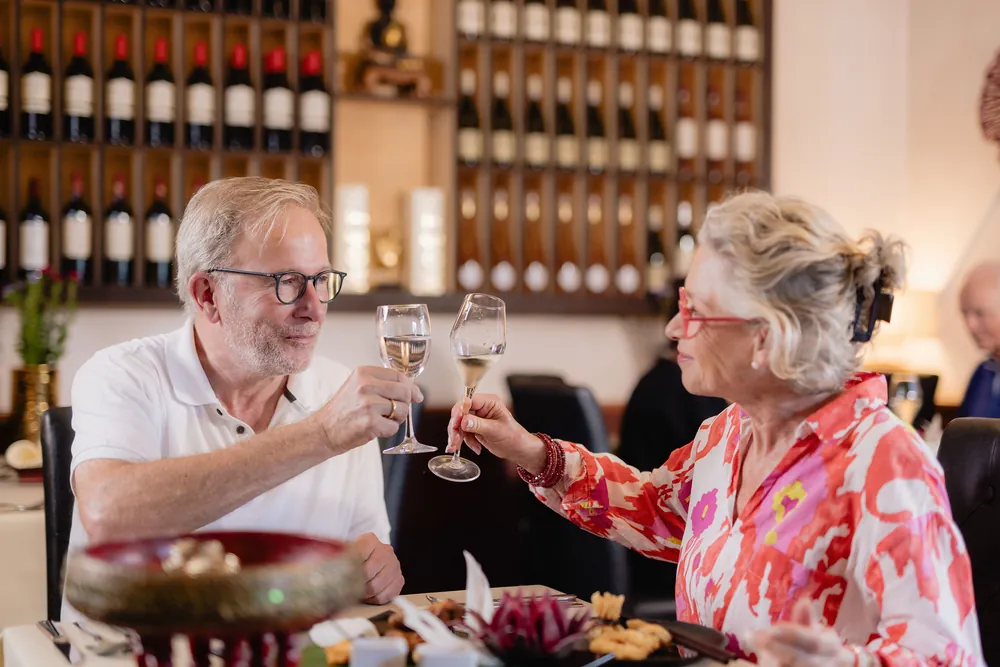 Zwei Gäste stoßen mit Wein an